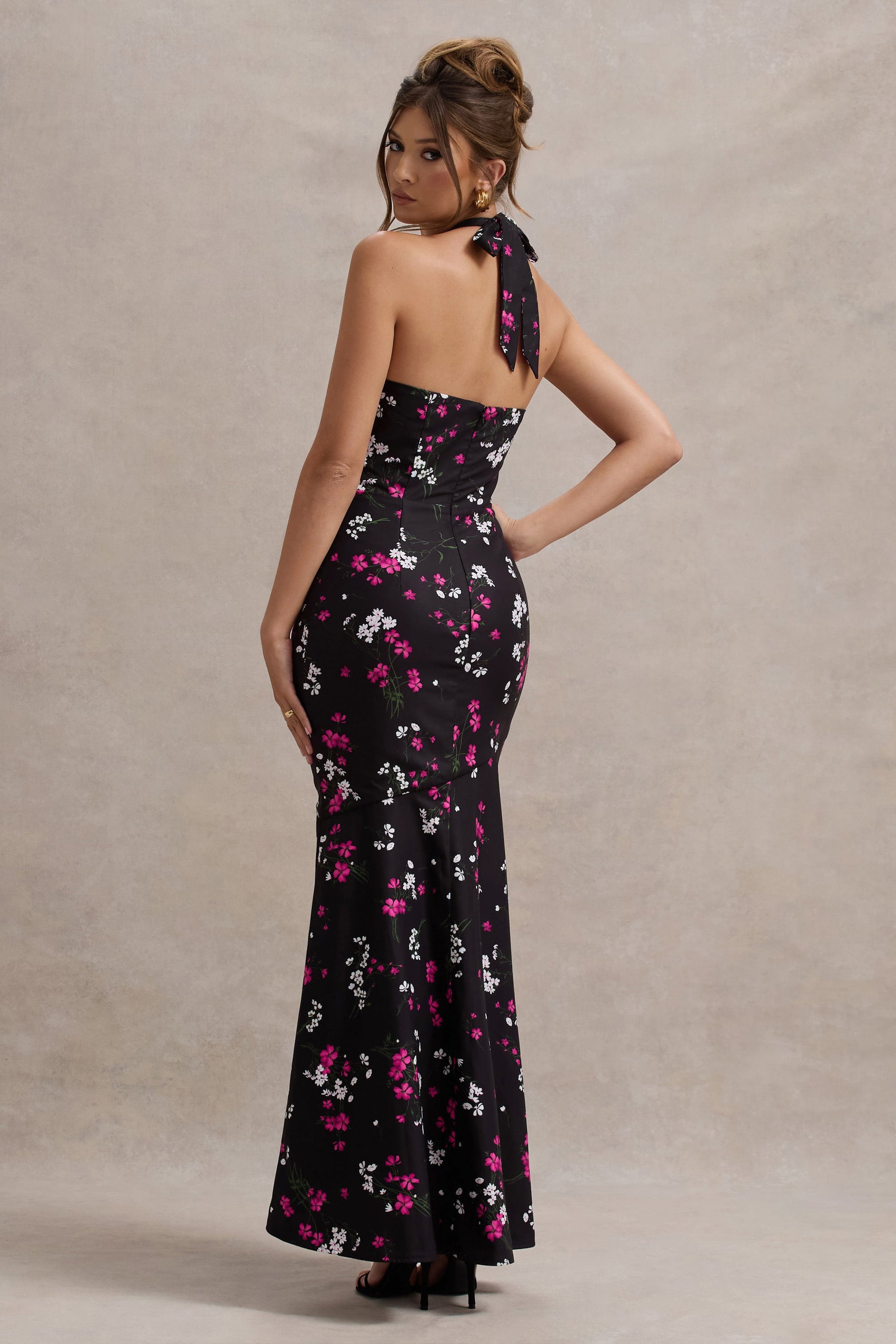 Melodia | Schwarzes Maxikleid aus Satin mit Gänseblümchenmuster, Rüschen und Halterneck-Ausschnitt.