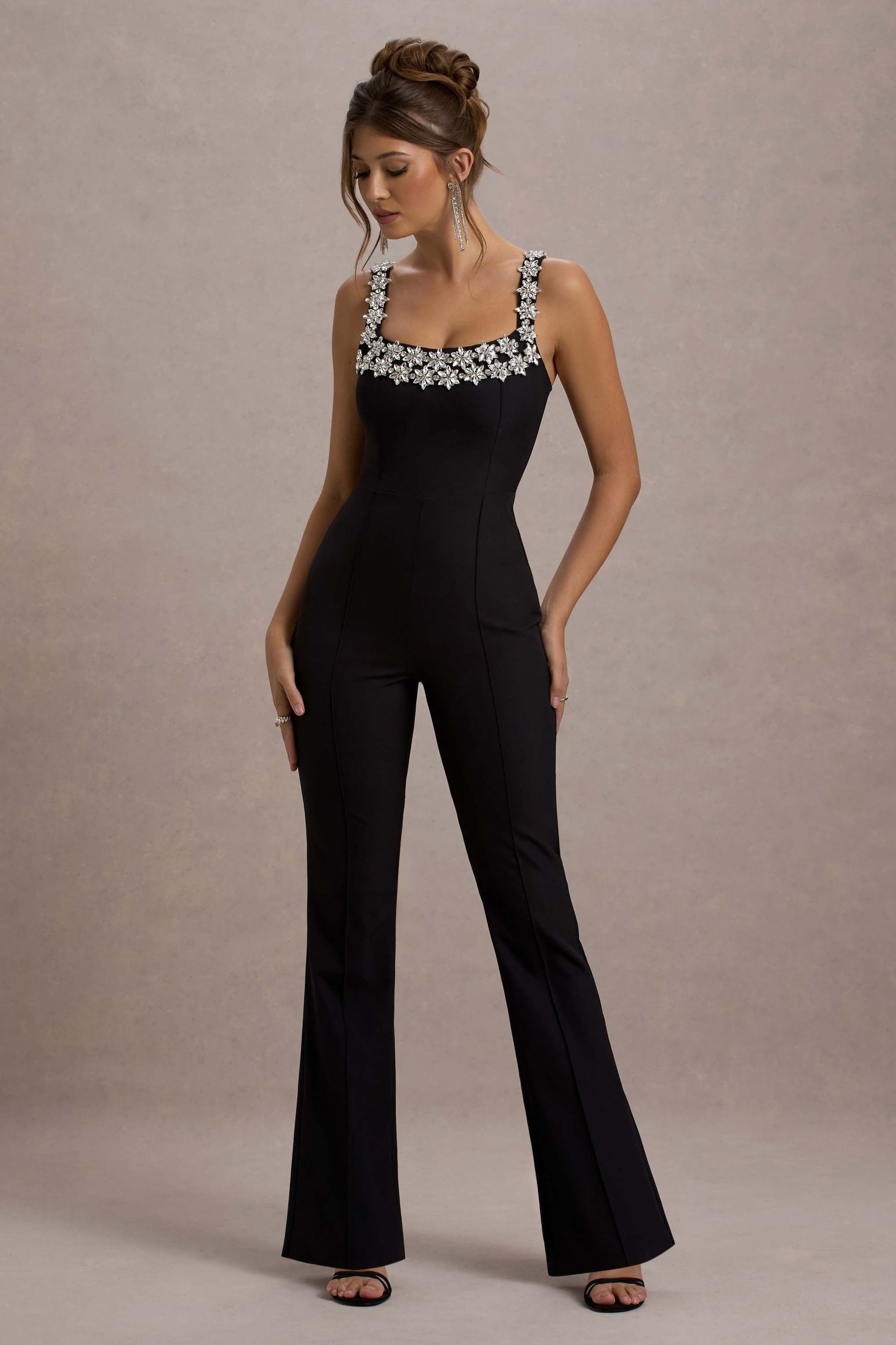 Amadi | Schwarzer Jumpsuit mit Verzierungen, Trägern und ausgestelltem Bein.