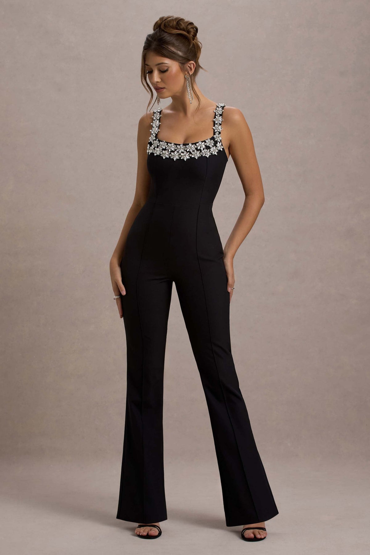 Amadi | Schwarzer Jumpsuit mit Verzierungen, Trägern und ausgestelltem Bein.
