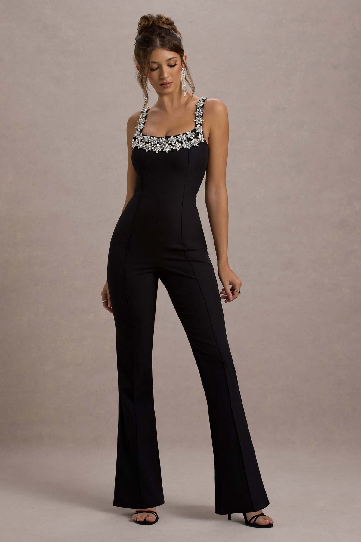 Amadi | Schwarzer Jumpsuit mit Verzierungen, Trägern und ausgestelltem Bein.