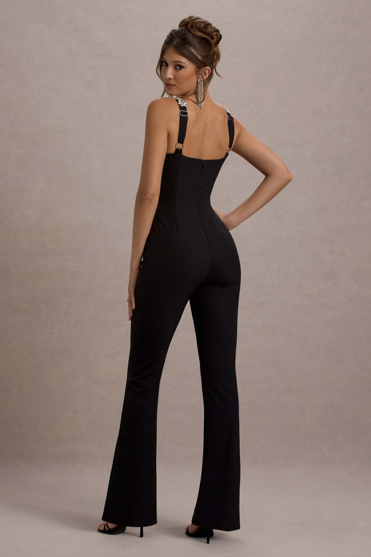 Amadi | Schwarzer Jumpsuit mit Verzierungen, Trägern und ausgestelltem Bein.