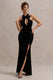 Mystery | Schwarzes Samt-Maxikleid mit tiefem Ausschnitt, Neckholder, Schlitz und Schleife.