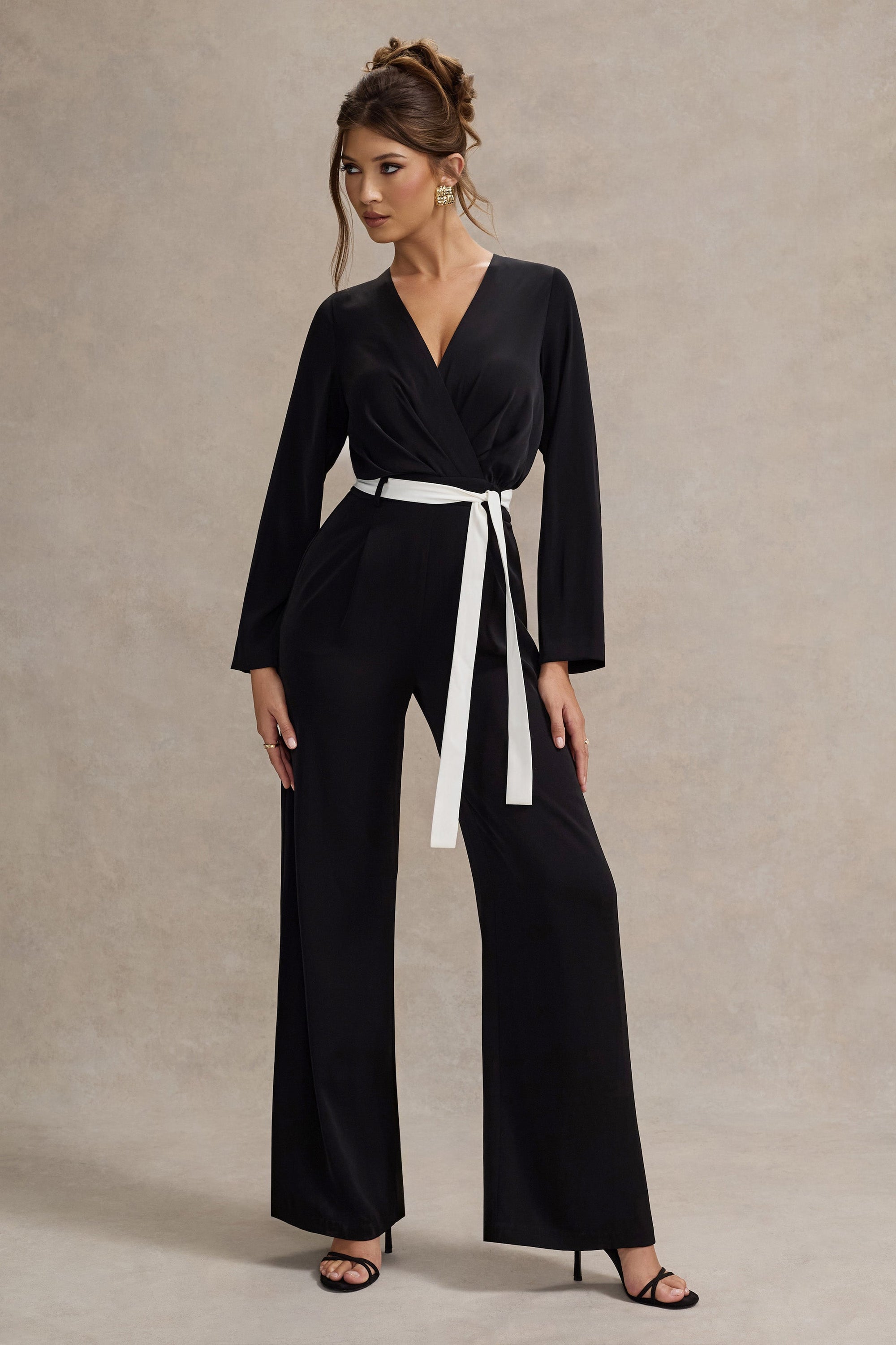 Ruba | Schwarzer, maßgeschneiderter Jumpsuit mit tiefem Ausschnitt und Bindegürtel.