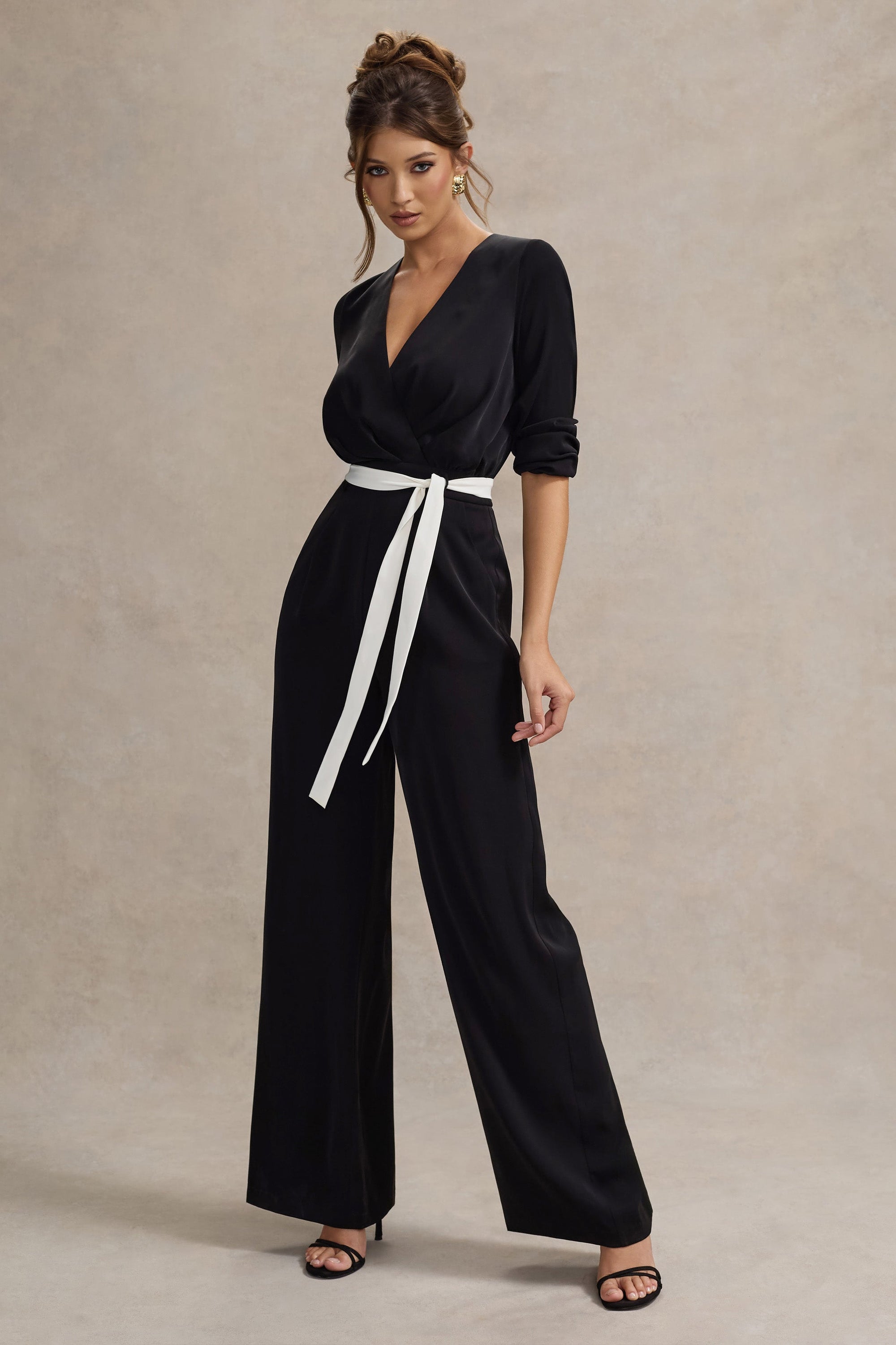 Ruba | Schwarzer, maßgeschneiderter Jumpsuit mit tiefem Ausschnitt und Bindegürtel.