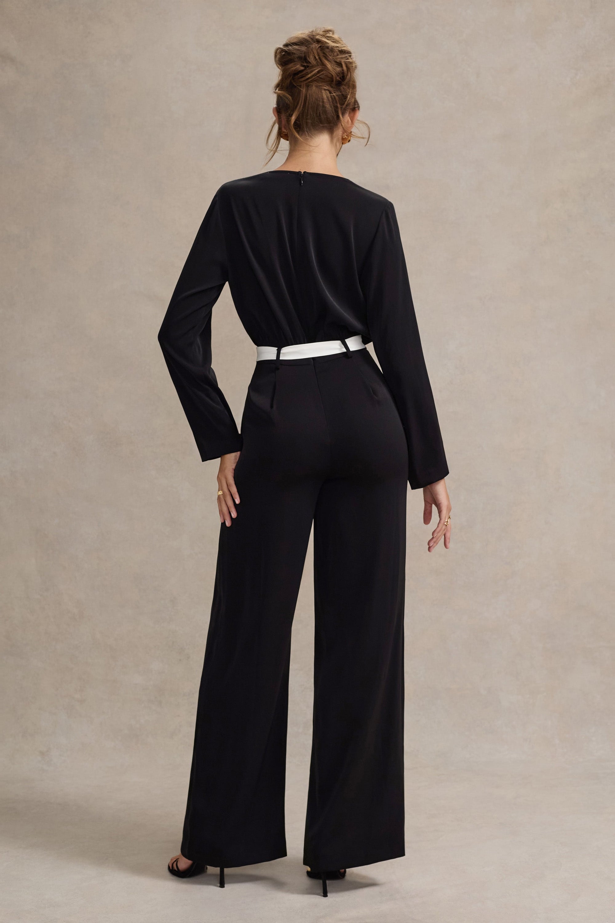 Ruba | Schwarzer, maßgeschneiderter Jumpsuit mit tiefem Ausschnitt und Bindegürtel.