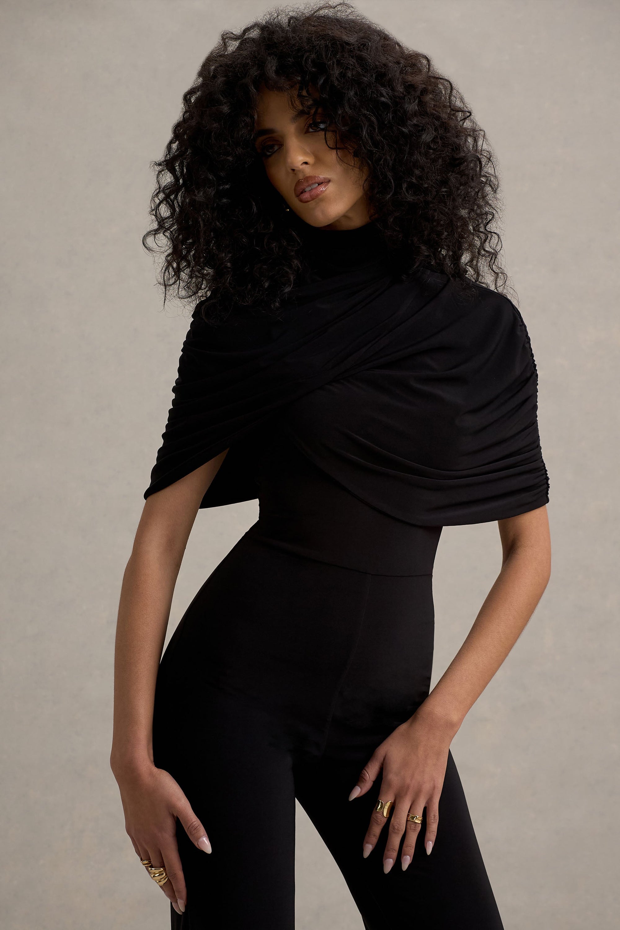 Isoline | Schwarzer Twist-Cape-Jumpsuit mit ausgestelltem Bein