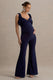 Impeccable | Marineblauer Umstands-Jumpsuit mit Sweetheart-Ausschnitt und Schleifenträgern.